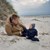 Far med spædbarn på stranden