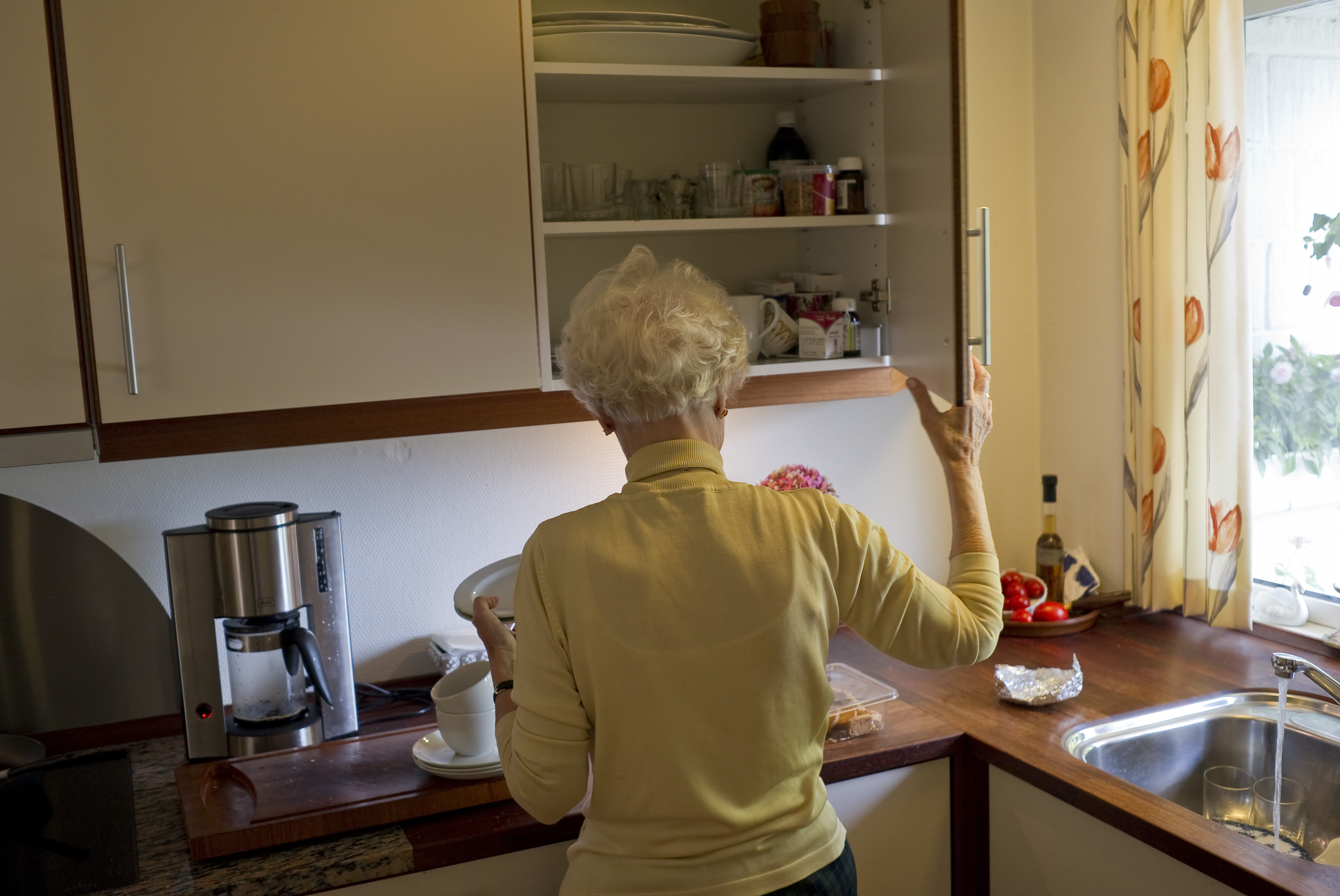 Ældre dame laver kaffe i sit køkken