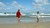 Børn der leger ved vandkanten på en sandstrand