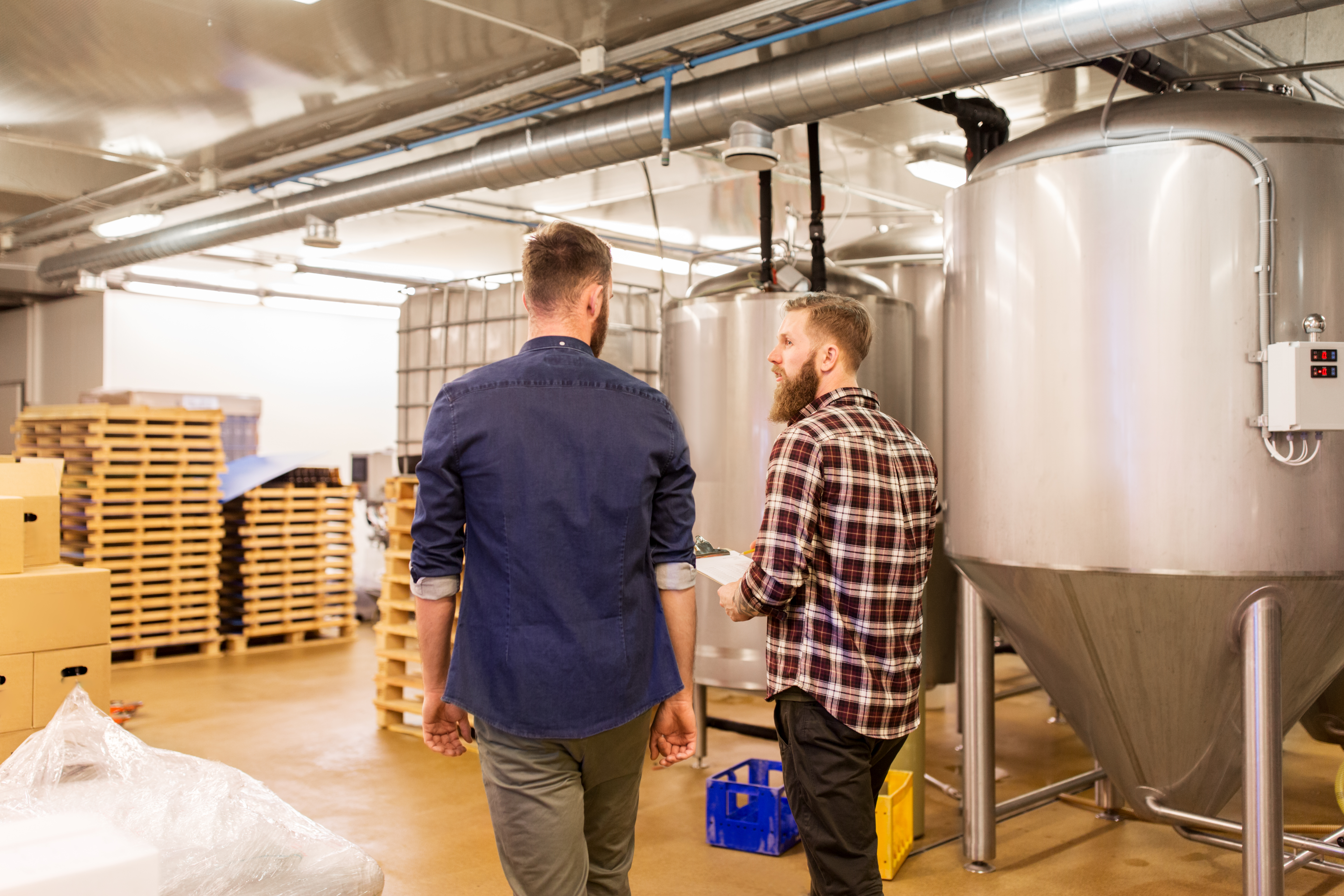 To personer går rundt på en industrifabrik