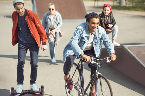 Unge mennesker cykler, skater og løber